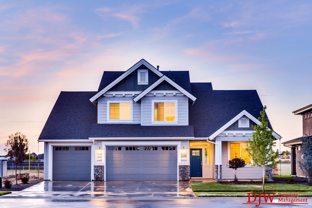 A three car garage suburban home that’s lit up and has a color scheme of blue, white, and gray tones.