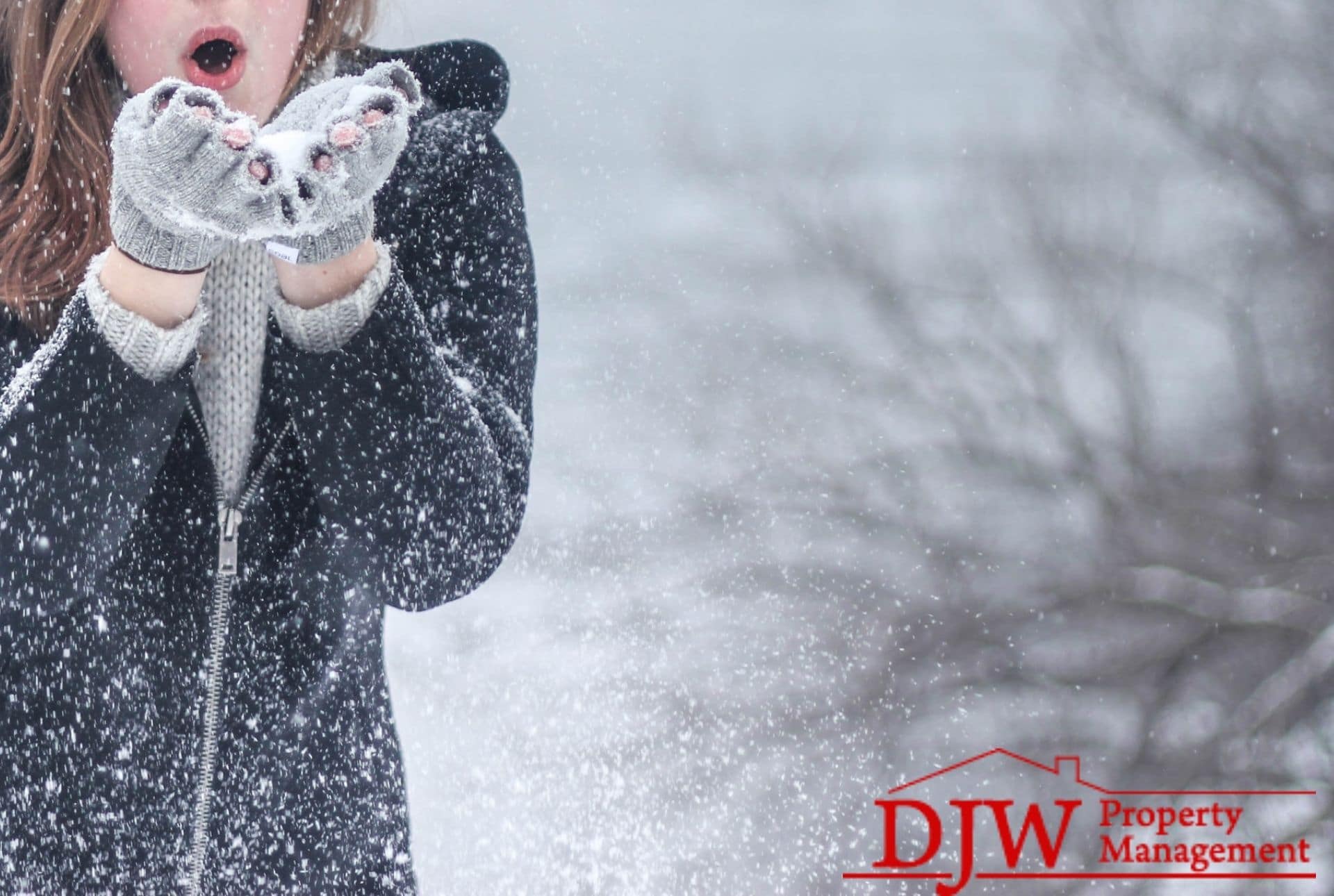 A woman blows snow from her fingerless gloves.