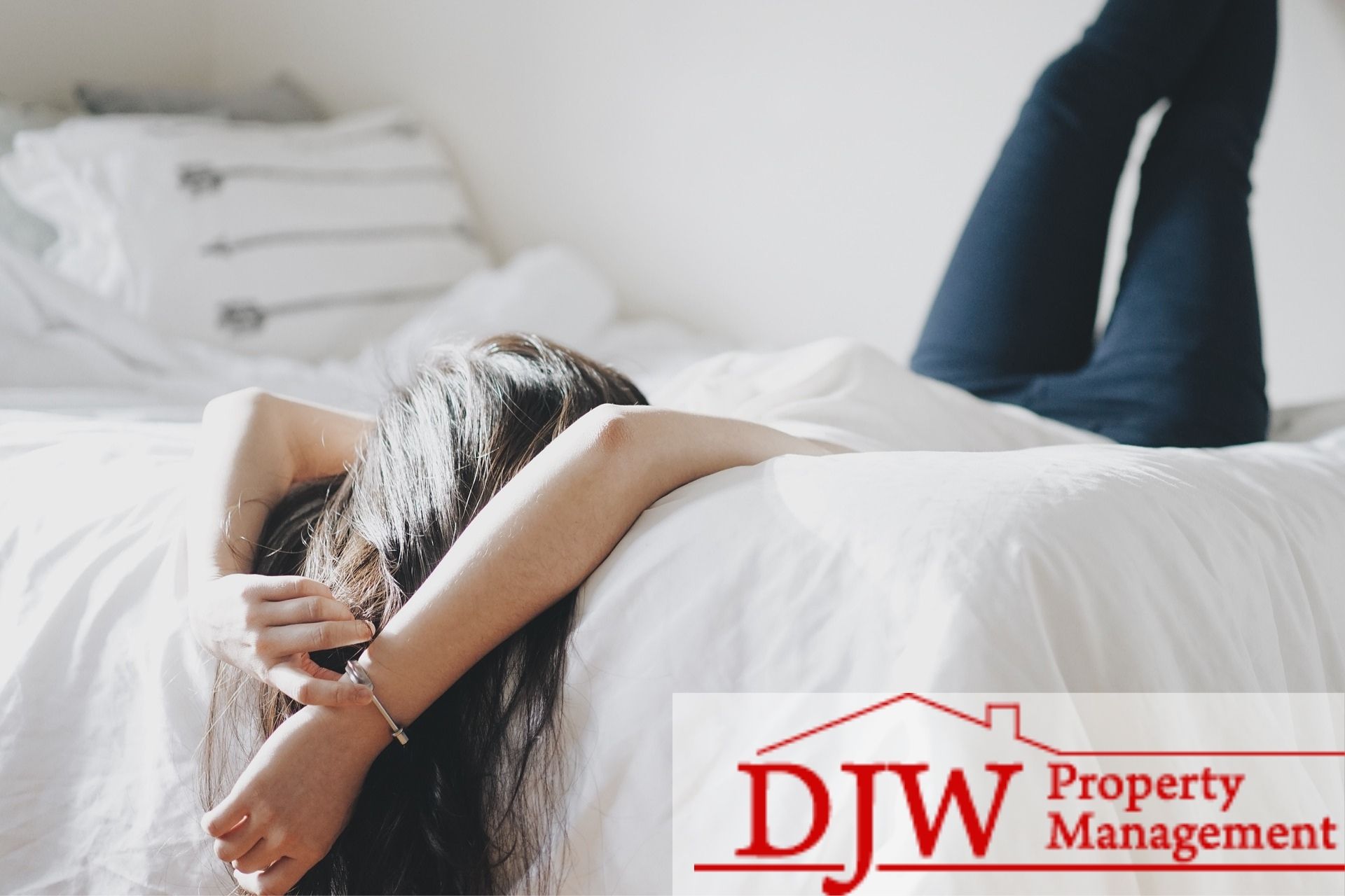 Girl laying down on her bed with her feet pressed against the wall