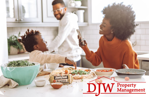 A family having fun in the kitchen making food with a child smiling into a mom’s camera.